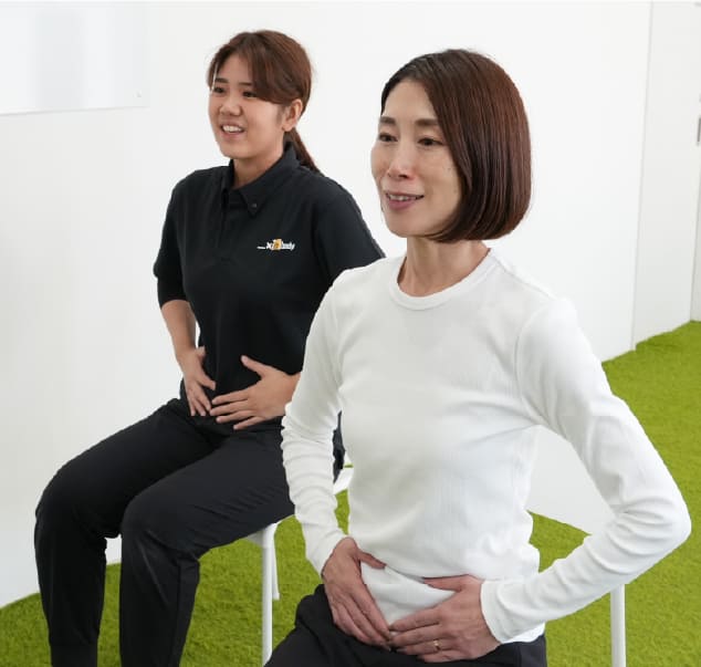 スタッフと一緒に座ってエクササイズを行う様子