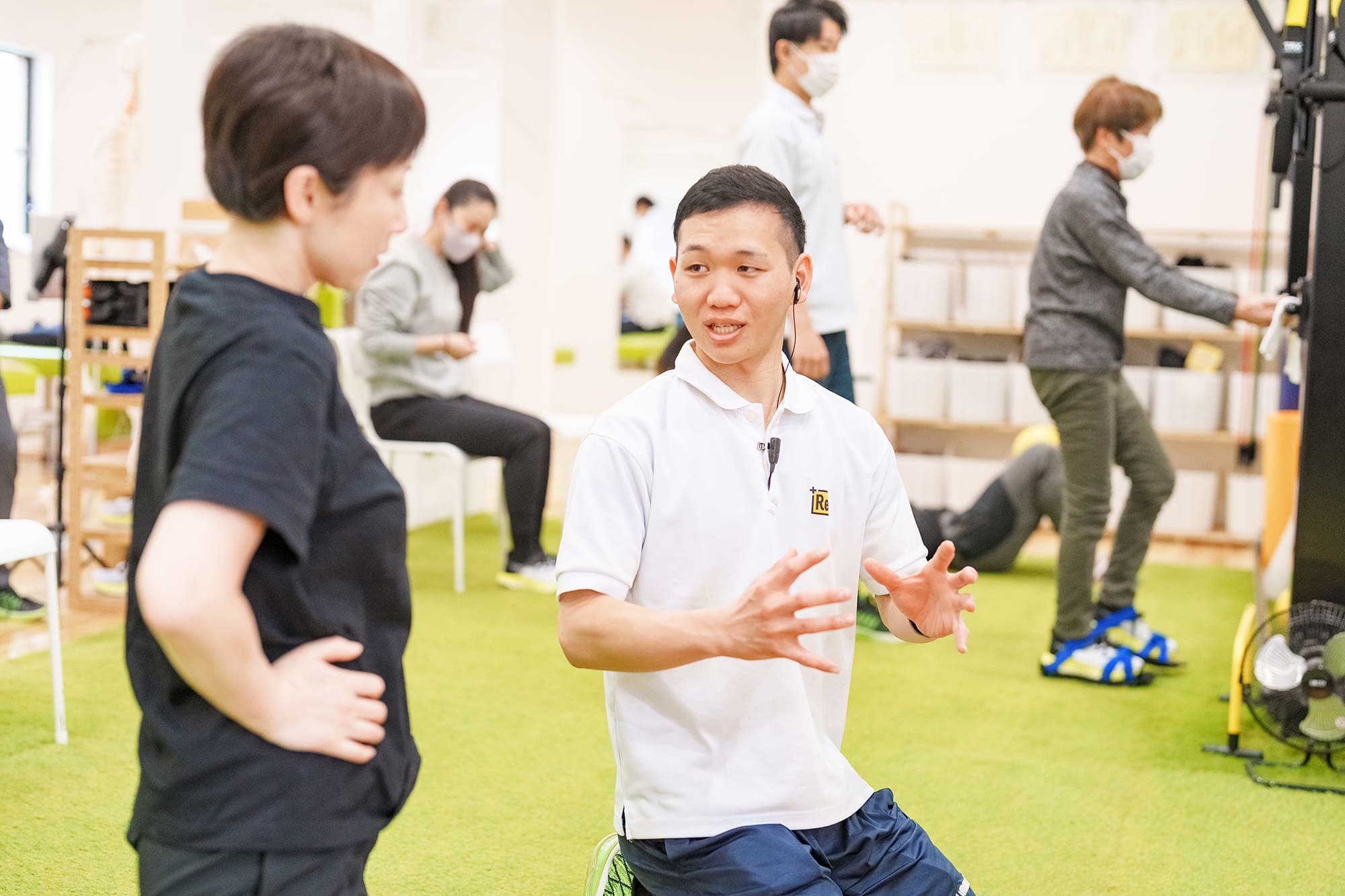 治療院でスタッフが患者へ運動療法を指導している様子